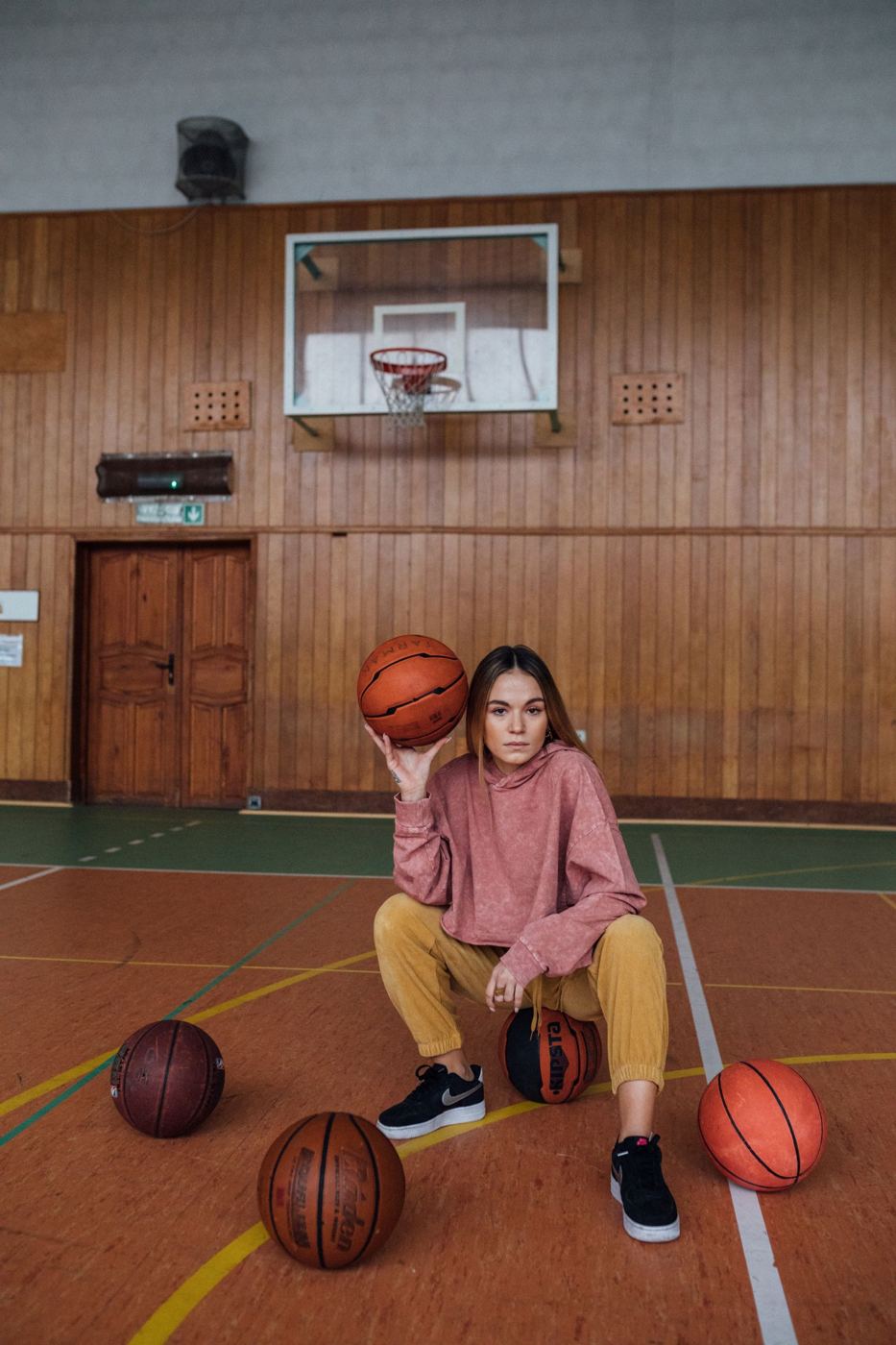 Kobieta z piłkami na hali sportowej